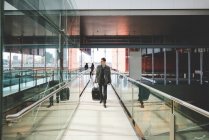 Young businessman commuter on railway concourse with suitcase. — Stock Photo