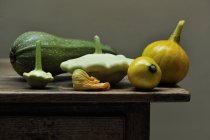 Fresh picked courgette and gourds on table — Stock Photo