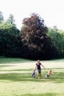 Mitte erwachsene Frau und zwei Töchter halten sich Händchen und rennen im Park — Stockfoto