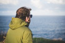 Uomo adulto che guarda il mare dalla costa ventosa, Sorso, Sassari, Sardegna, Italia — Foto stock