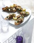Plate of mushroom and spinach bruschetta with lemon slice — Stock Photo