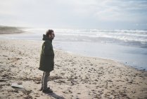 Hombre adulto mirando al mar en la playa ventosa, Sorso, Sassari, Cerdeña, Italia - foto de stock