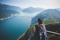 Середині дорослу жінку на балконі з видом на озеро Лугано, Швейцарія — стокове фото