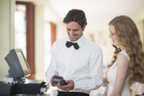 Waiter and female customer using credit card machine in restaurant — Stock Photo