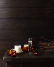Holztisch mit brennenden Kerzen und Glas Champagner — Stockfoto