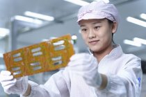 Arbeiter hält Schaltung in High-Tech-Fabrik — Stockfoto