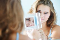 Над видом на плече дівчини-підлітка дзеркальні відображення — стокове фото