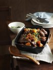 Stufato di coda di bue mediorientale nel piatto da portata con cucchiaio da portata in legno — Foto stock