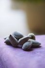 Almonds in shells on purple tablecloth, close up shot — Stock Photo