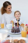 Teenage girl and toddler at patio table for birthday party — Stock Photo
