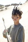 Мальчик в маскарадном платье, держа в руках лук и стрелы — стоковое фото