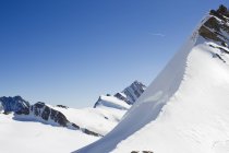 Vista de las montañas cubiertas de nieve bajo cielo azul claro - foto de stock