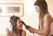 Giovane donna che fa i capelli di un amico — Foto stock