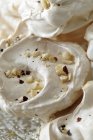Meringues decorated with crashed nuts, close up shot — Stock Photo