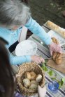 Femme âgée coupe le pain, vue grand angle — Photo de stock