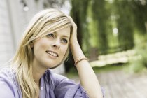Close up portrait of mid adult woman sitting in garden — Stock Photo