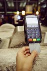 Mano de mujer usando la máquina de la tarjeta de crédito para el pago del restaurante - foto de stock