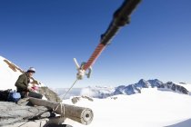Caminhante do sexo masculino comer lanches na plataforma de visualização, Jungfrauchjoch, Grindelwald, Suíça — Fotografia de Stock