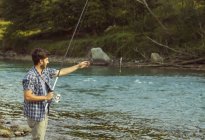 Young man catching fish in river, Premosello, Verbania, Piemonte, Italy — Stock Photo