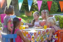 Дівчина з друзями за столом з тортами на день народження — стокове фото
