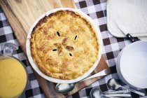 Top view of homemade pie with custard and spoons on table — Stock Photo