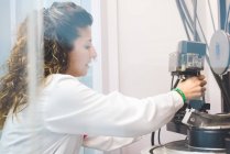 Жінка-вчена, що змінює рентгенівський детектор на рентгенівському дифрактометрі — стокове фото