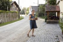 Reife Frau über den Weg, Tablett mit Kuchen und Getränken — Stockfoto