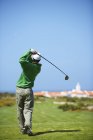 Vista traseira do golfista segurando clube de golfe tomando balanço de golfe — Fotografia de Stock