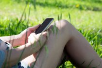 Ausgeschnittene Ansicht einer jungen Frau mit Smartphone — Stockfoto