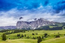 Campos e formação rochosa distante, Dolomites, Itália — Fotografia de Stock