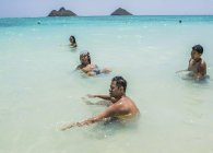 Quatre jeunes amis adultes jouent en mer à Lanikai Beach, Oahu, Hawaï, États-Unis — Photo de stock