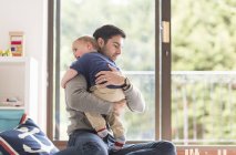 Father hugging young son, indoors — Stock Photo