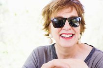 Портрет щасливої зрілої жінки в сонцезахисних окулярах — стокове фото