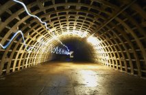 Traînées lumineuses à longue exposition dans le tunnel — Photo de stock
