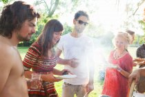 Adult friends waiting for BBQ at sunset park party — Stock Photo