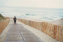 Серфер с доской для серфинга, идущий к пляжу, Лаканау, Франция — стоковое фото