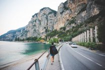 Tourist walking along road by Lake Garda, Italy — Stock Photo