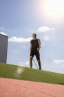 Sportler läuft mit Wanderstock auf Feld — Stockfoto