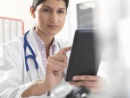 Médico femenino usando la pantalla táctil digital de la tableta para los expedientes médicos - foto de stock