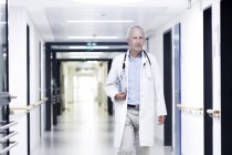 Male doctor walking along corridor — Stock Photo