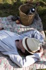 Зрелая женщина отдыхает на одеяле на лесной подстилке — стоковое фото