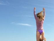 Vista posteriore di giovane donna che salta a mezz'aria, Altona, Melbourne, Victoria, Australia — Foto stock