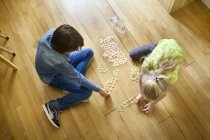 Brother and sister counting coins from savings jar — Stock Photo