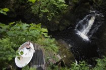 Vista de alto ângulo da mulher madura no banho de bolhas na frente da cachoeira no retiro ecológico — Fotografia de Stock