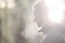 Side view of mid adult man looking away, condensation from breath — Stock Photo
