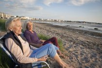 Mother and daughter enjoying view on beach — Stock Photo