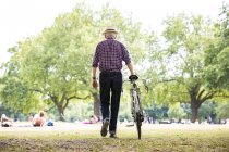 Homem sênior com bicicleta no parque, Hackney, Londres — Fotografia de Stock