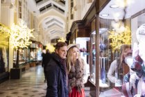 Pareja joven ventana de compras en Burlington Arcade en Navidad, Londres, Reino Unido - foto de stock