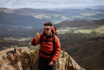 Молодой турист делает селфи со смартфона в горах, Озерный край, Камбрия, Великобритания — стоковое фото