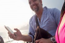 Человек, использующий смартфон, пляж Ипанема, Рио-де-Жанейро, Бразилия — стоковое фото